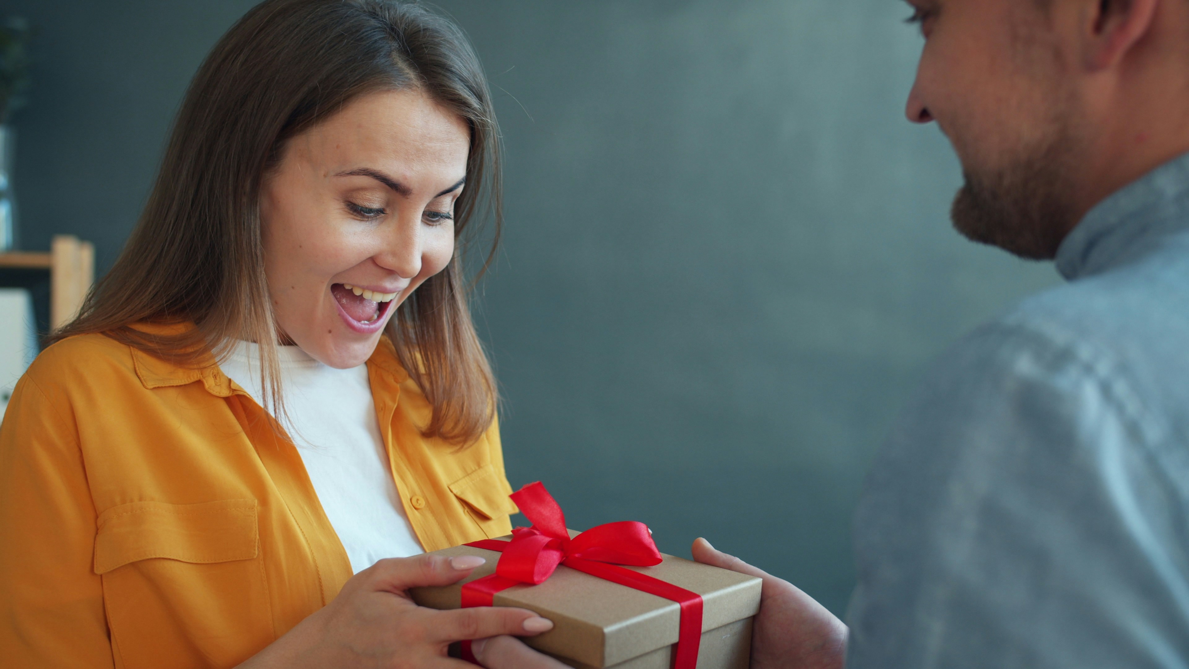 Ein Geschenk wird überreicht – Gutschein als Geschenkidee
